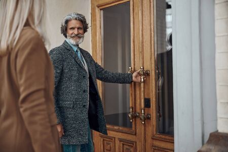 Gentleman opening the door for lady stock photoの写真素材