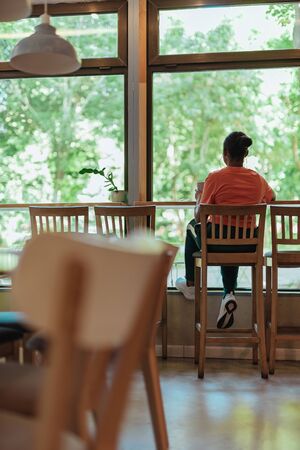 Young afro-american woman sitting in cafe near window