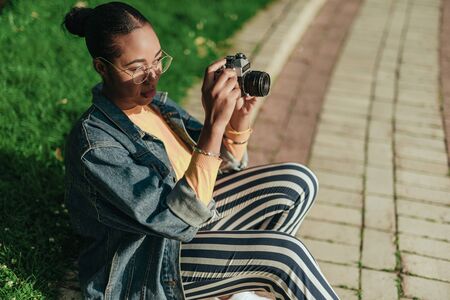 Young african american woman taking photo at old camera