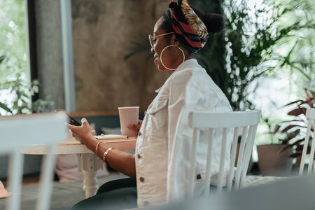 Young afro american woman is holding smartphone