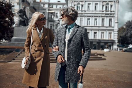 Mature elegant couple walking and smiling stock photoの写真素材