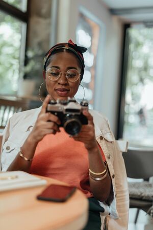 Young african american woman using photo cameraの写真素材