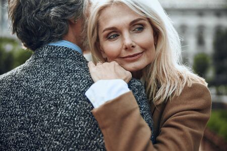 Peaceful woman hugging shoulder of man stock photoの写真素材
