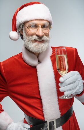 Santa Claus holding glass of champagne in handの写真素材