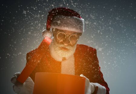 Elderly Santa Claus holding box with light insideの写真素材