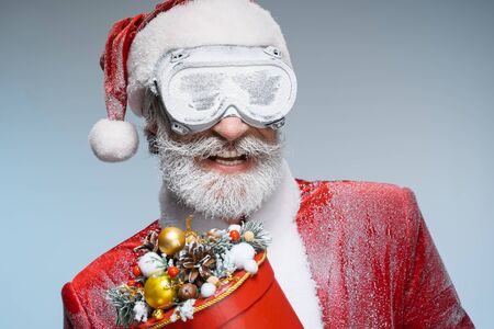 Senior Santa Claus holding new year present in handsの写真素材