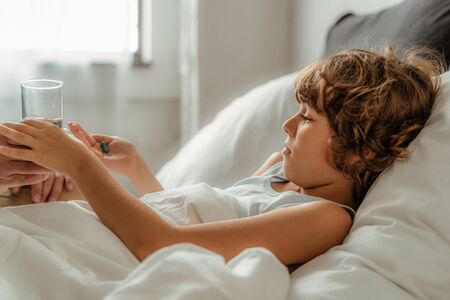 Father giving pills to his sick sonの写真素材
