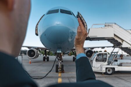 Man taking photos with airplane in airportの写真素材