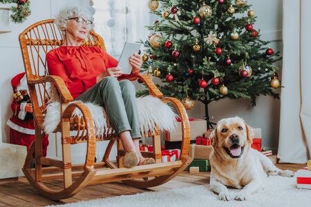 Old woman is sitting in chair at homeの写真素材