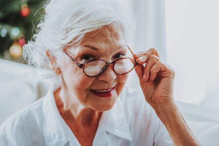 Charming old woman is looking at cameraの写真素材
