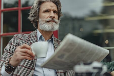 Handsome senior man enjoying coffee at outdoor cafe
