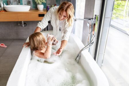 Mom and daughter looking at each other in bathroom