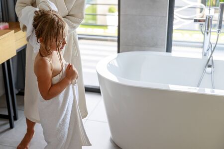 Mom standing near daughter with a towel