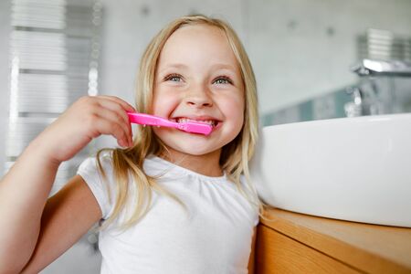 Smiling cute girl is holding a toothbrushの写真素材