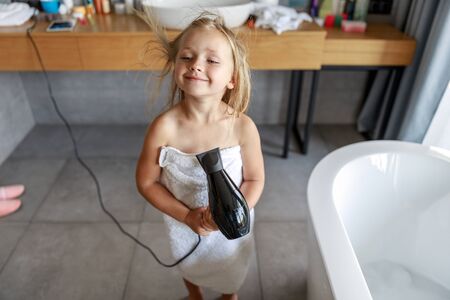 Happy girl with wet hair in the bathroomの写真素材