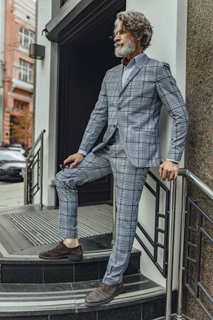 Stylish bearded gentleman standing on the streetの写真素材