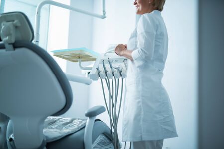 Female doctor is standing near dental chairの写真素材