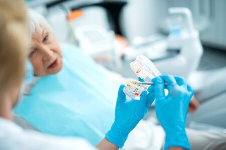 Dentist with adult patient in dental office
