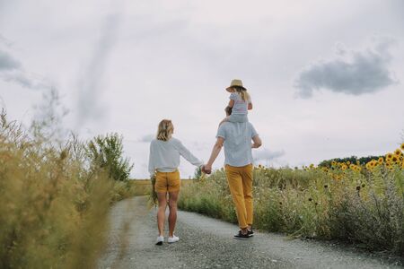 Beautiful young family keeping hands together on the road outdoorsの写真素材