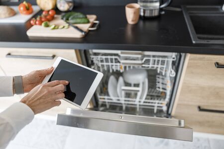 Woman including dishwasher and using a tabletの写真素材