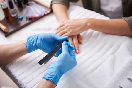 Manicurist preparing for manicure session while client waiting