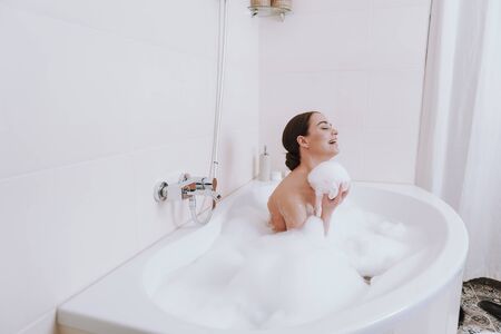 Joyful smiling woman enjoying time in the bathroom