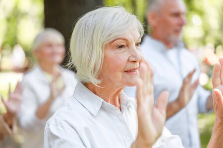 Smiling mature woman practicing qigong in the parkの写真素材