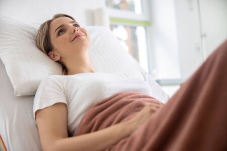 Charming young woman resting in hospital room