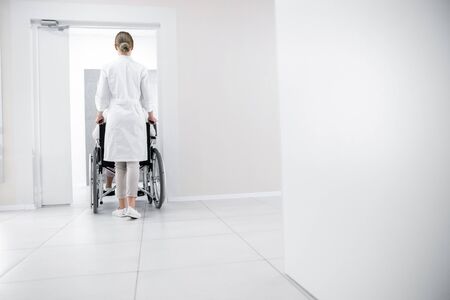 Back view of doctor with patient in hospital