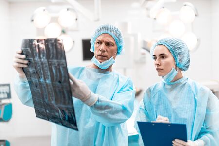Worried specialists looking at the x-ray results and frowning