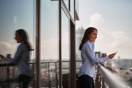 Young office woman enjoying city view on balconyの写真素材