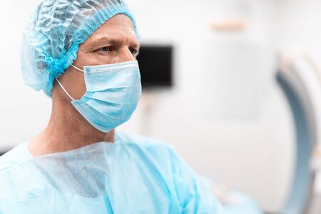 Close up of serious doctor with medical mask on his face