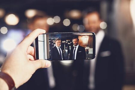 Close up of modern device with smiling friends on the screenの写真素材