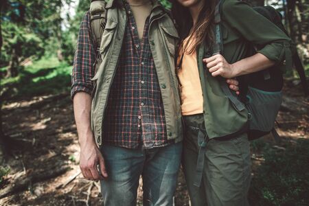 Traveler couple standing embracing in green forestの写真素材