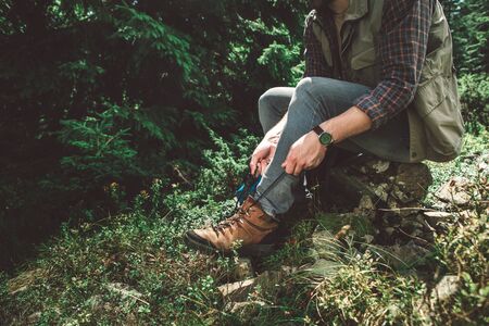 Traveler man taking break on green mountain hill