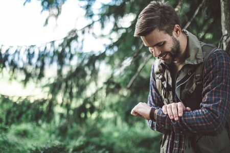 Man looking at his watch travelling in forestの写真素材