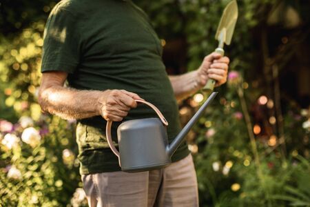 Older gardener going to work in backyardの写真素材