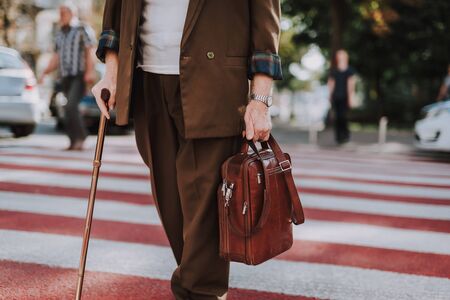 Stylish old man walking across the streetの写真素材