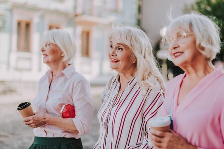 Smiling elderly women are drinking a coffeeの写真素材