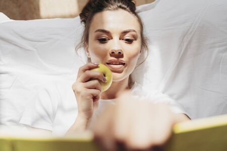Pretty young woman is lying in bedroom