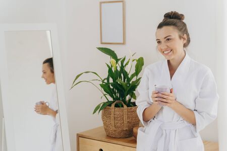 Happy young woman is staying in bedroom