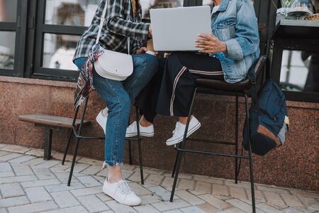 Cropped photo of two colleagues working on a computer in a cafeの写真素材