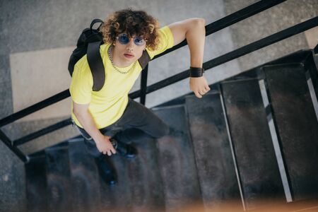 Stylish handsome teenager on steps outdoors stock photo
