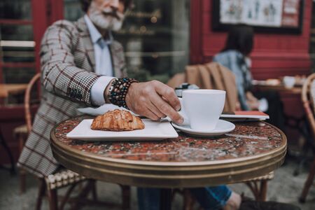 Man taking coffee from the table stock photoの写真素材