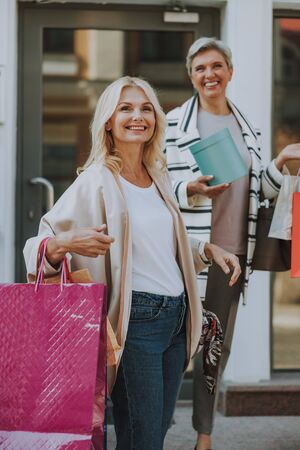 Two happy attractive fashionistas doing shopping togetherの写真素材
