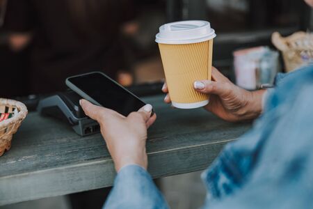Female buying a cup of coffee outdoorsの写真素材