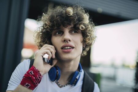 Carefree boy talking on cell phone outdoors stock photo