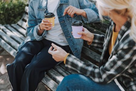 Two women sitting on a wooden benchの写真素材