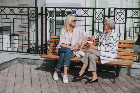 Two stylish women talking on the terrace