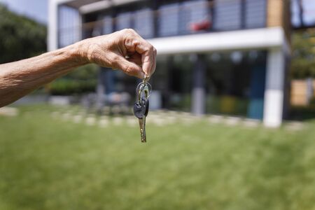 Adult woman in holding key from houseの写真素材